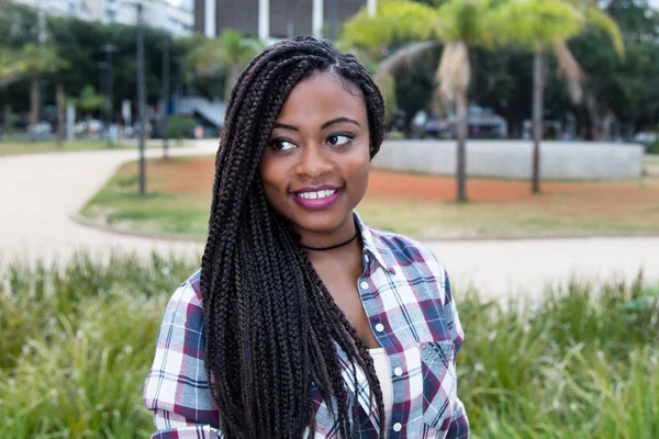 Afrikaanse vrouw met dreadlocks zijwaarts op zoek — Stockfoto