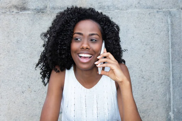 Riéndose mujer afroamericana en el celular —  Fotos de Stock