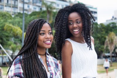 İki Afrikalı-Amerikalı kadın gülüyor