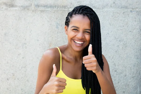 Glücklich lachende afrikanisch-amerikanische Frau mit Dreadlocks zeigt th — Stockfoto
