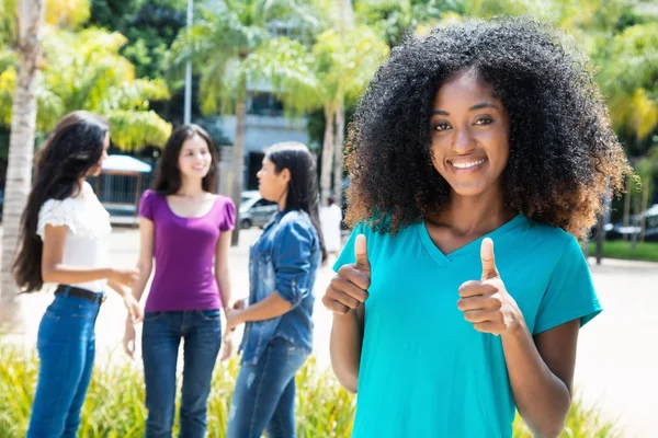 African american kobieta pokazując kciukiem z grupy koleżanek — Zdjęcie stockowe