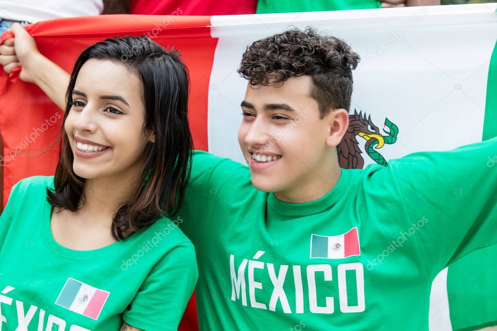 Happy soccer fans from Mexico with mexican flag
