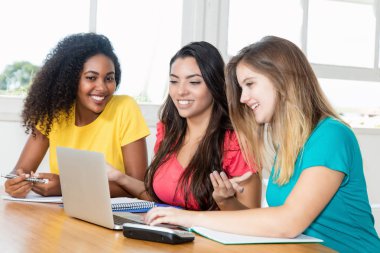 Üç kız öğrenci bilgisayar başında öğrenme
