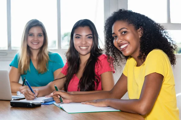 Três estudantes do sexo feminino aprendendo em sala de aula — Fotografia de Stock