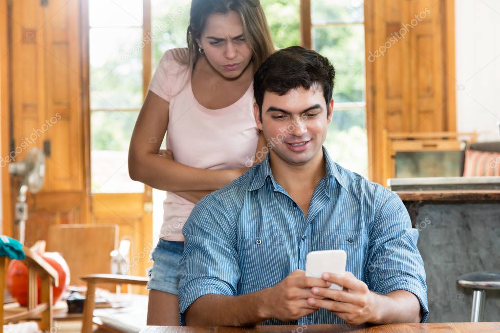Jealousy woman checking chat on cellphone of boyfriend