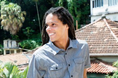 Latin Amerika genç yetişkin adam yana doğru seyir dreadlocks ile