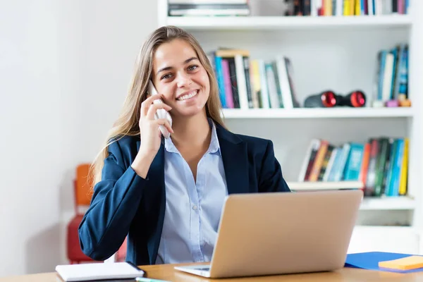 Blonde zakenvrouw spreken met klant bij telefoon — Stockfoto
