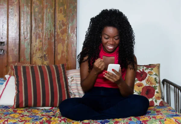 Cheering african american woman with phone