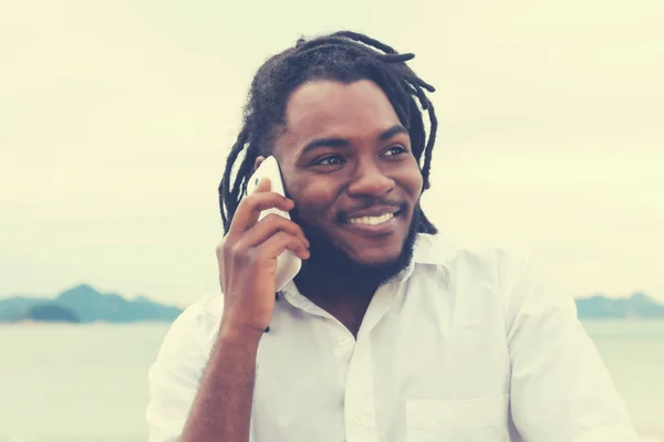 Afryki amerykański facet z dredy i białej koszuli na telefon w — Zdjęcie stockowe