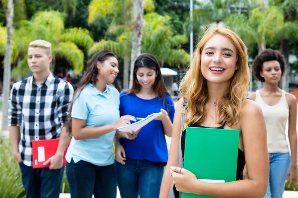 Güzel Amerikalı kadın öğrencinin grup uluslararası insan Üniversitesi kampüsünde açık