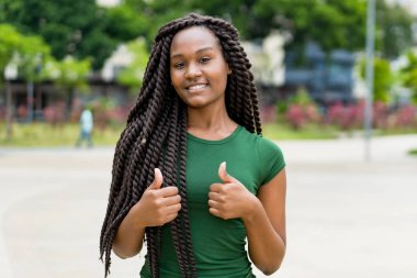Harika saç stili olan mutlu Afrikalı Amerikalı genç yetişkin kadın.