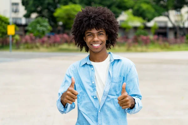 Gelukkig afrikaanse amerikaanse hipster jong volwassene tonen duimen omhoog — Stockfoto