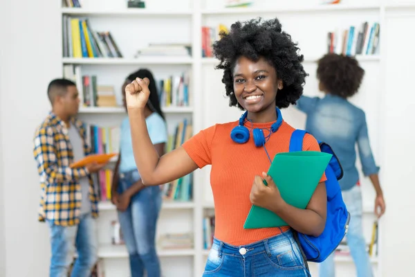 Jublande afrikansk amerikansk kvinnlig student med grupp av studenter — Stockfoto