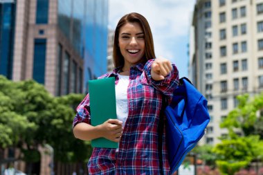 Ambitious hispanic female student in city clipart