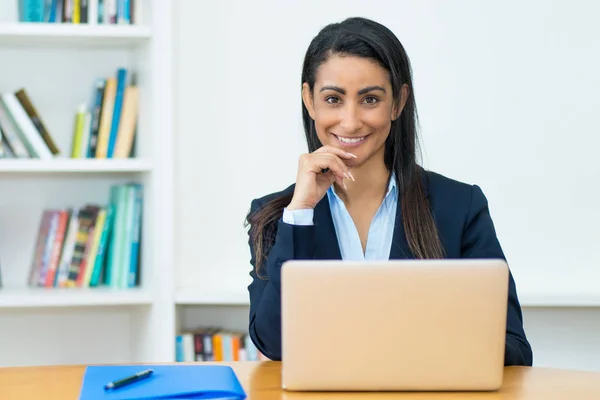 Hermosa latinoamericana madura mujer de negocios con chaqueta en com — Foto de Stock