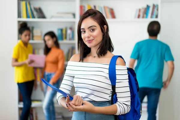 Krásná kavkazská studentka se skupinou studentů — Stock fotografie