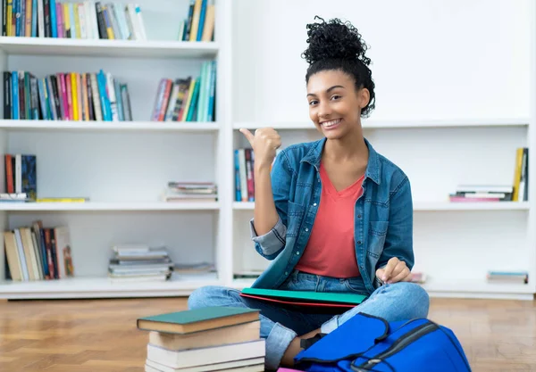 Joven estudiante latinoamericana con libros y papeleo — Foto de Stock