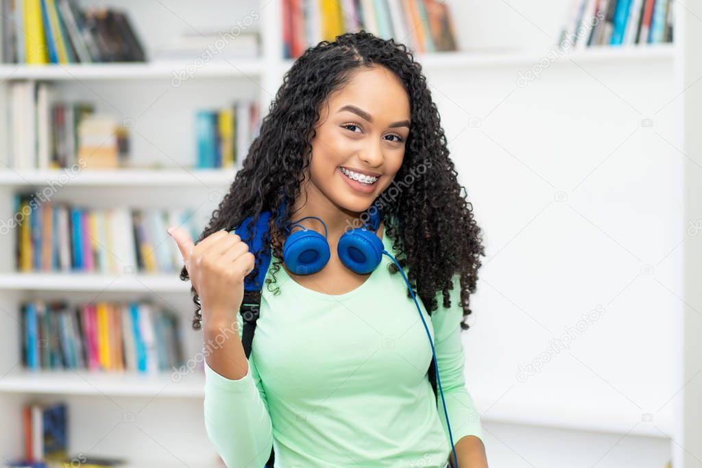Beautiful brazilian female student with retainer and headphone