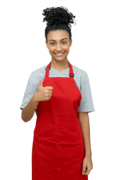 Empregada latino-americana com avental vermelho mostrando polegar para cima — Fotografia de Stock