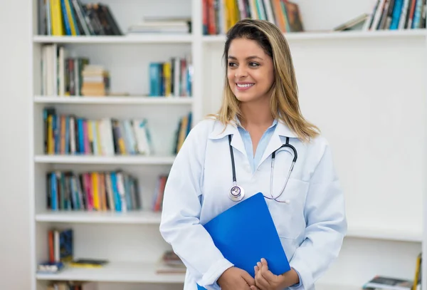 Blond vrouwelijke arts op zoek naar patiënt — Stockfoto