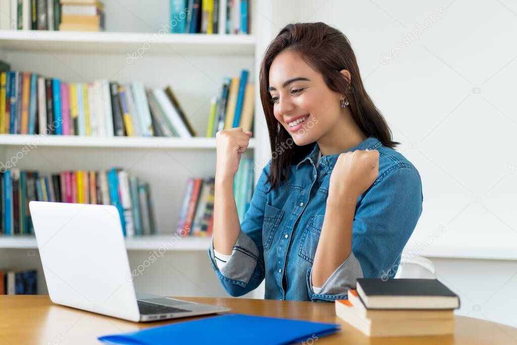 Successful young adult female student working at computer at university