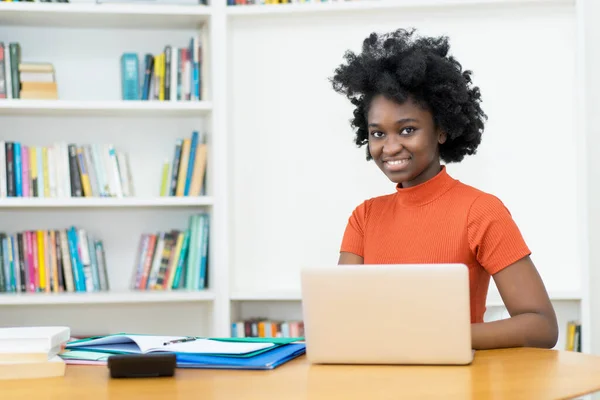 かなりアフリカ系アメリカ人の若い大人の女性でコンピュータで大学 — ストック写真