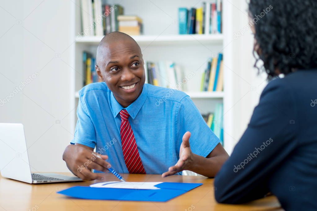 Job interview of african american businessman with applicant at office