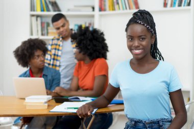 Korkuyla ve üniversite sınıfında bir grup öğrenciyle oldukça Afrikalı Amerikalı genç bir yetişkin.