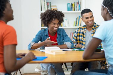 Bir grup Afrikalı ve Güney Amerikalı öğrenci üniversite sınıfında tartışıyorlar.
