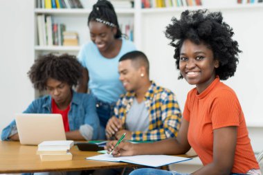 Üniversite sınıfında bir grup öğrenciyle Afrika kökenli Amerikalı bilgisayar bilimleri öğrencisi.