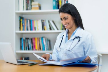 Hastanede çalışan gülen Brezilyalı kadın doktor.