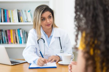 Kadın doktor hastaya teşhis ve terapi hakkında konuşuyor.