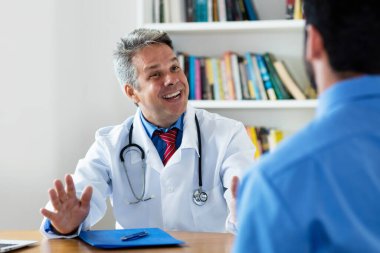 Olgun doktor, klinikte hastalara sosyal mesafe öneriyor.