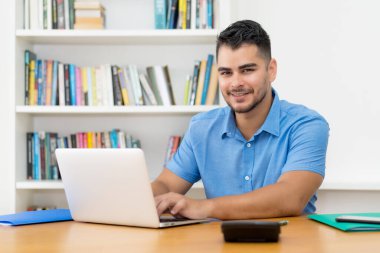 Evde bilgisayar başında çalışan sakallı İspanyol hippi.