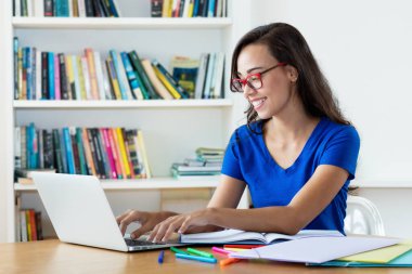 Evde bilgisayar kullanarak internetten inek öğrenci öğreniyor.