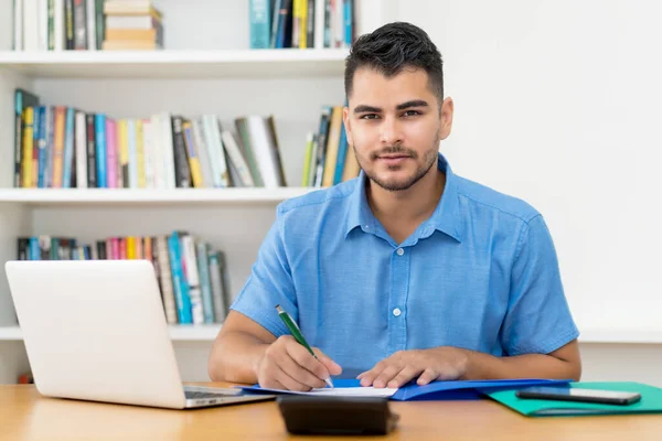 Handsome hispanic hipster man stay at home and working at home office