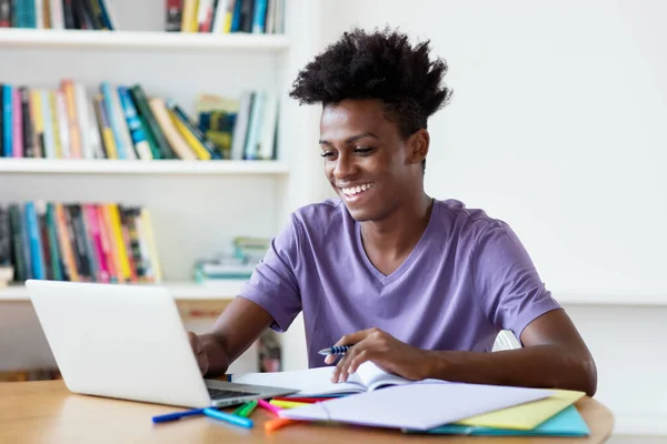 非洲裔美国男性青年在家里的电脑上流播和观看短片和电影 — 图库照片