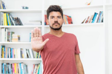 İspanyol adam evde koronavirüs enfeksiyonundan kaçınmak için el kol hareketi yapıyor.