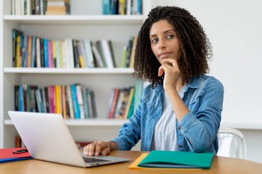 Güzel Latin kız öğrenci evde bilgisayar öğreniyor.