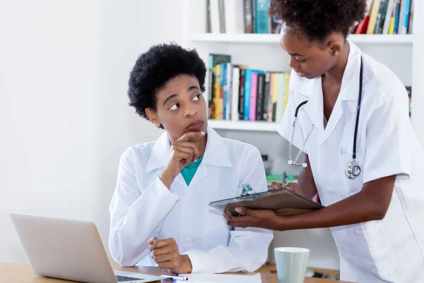 간호사와 일하거나 병원이나 진료소에서 일하는 아프리카 미국인 — 스톡 사진