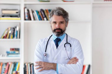 Hastanede gri saçlı, ciddi bir yetişkin doktor.