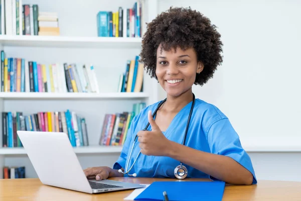 Pretty afro american nurse or medical student at computer at hospital