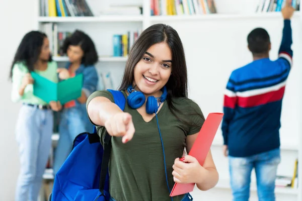 Aspiring spanish female student with group of students at university