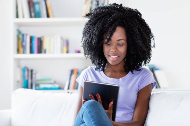 Karantinadaki Afrikalı Amerikalı kadın evde dijital tablet bilgisayarla çalışıyor.