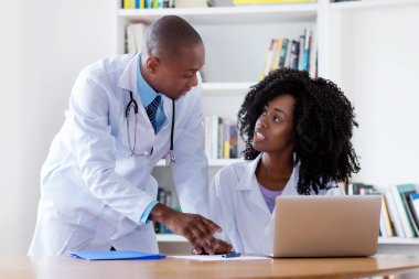 Afro-Amerikalı yetişkin erkek doktor ve hastanede hemşire.