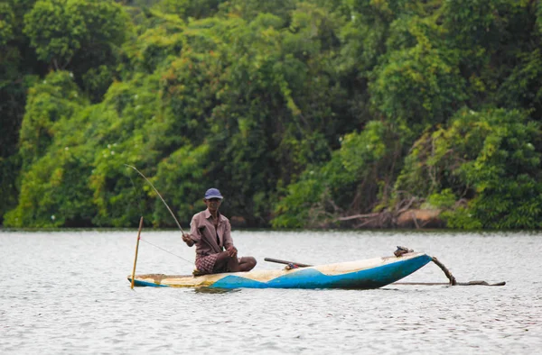 Sri Lankan Fluss, srilankischer Tourismus, Fischer vom See in Aktion beim Angeln in der Dämmerung, srilankische Kultur und Tourismus. Holzboot mit Angelrute. — Stockfoto