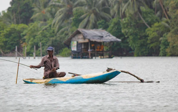 Srí Lanka, srilankan cestovního ruchu, Rybář jezera v akci při rybolovu za soumraku, Srilankan kultury a turistiky.dřevěný člun s rybářským prutem. — Stock fotografie