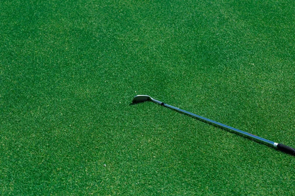 녹색 풀 위에 있는 철제 골프채와 공의 꼭대기 모습 — 스톡 사진