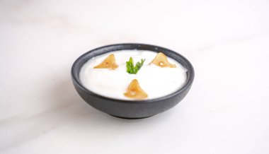 Garlic sauce in a bowl with few pieces of garlic topping.