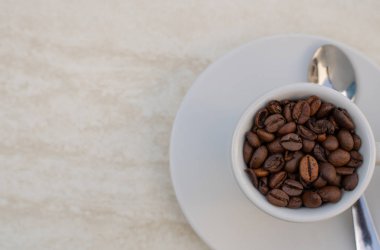 Beyaz arka planda kahve fincanı ve fasulye. Metnin için kopyalama alanı olan üst görünüm